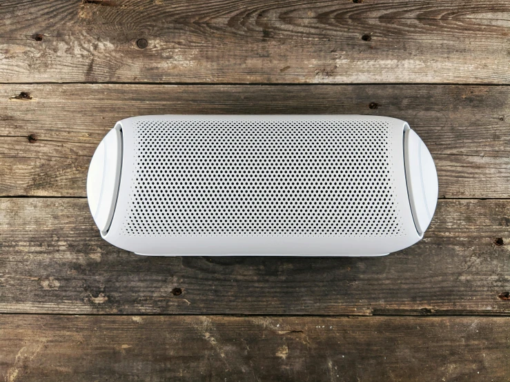 a speaker is sitting on a wood surface