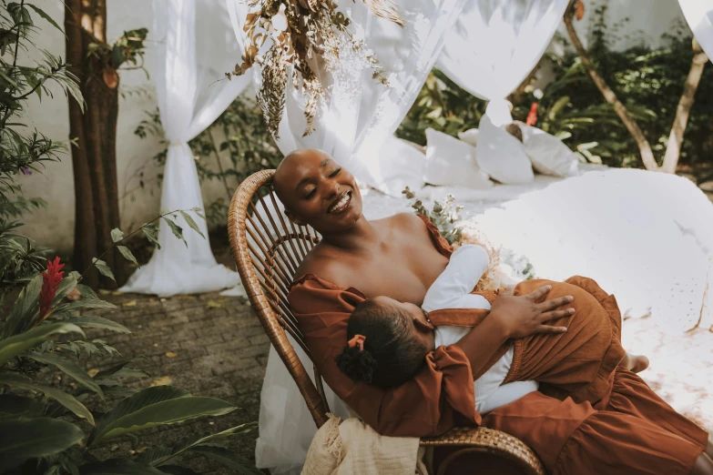 a man is holding his baby outdoors under a canopy