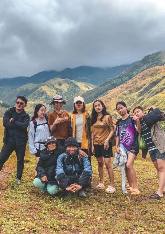 a group of tourists pose for a po near the edge of a mountainous valley