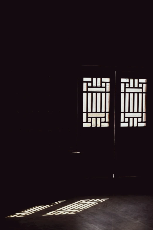 two windows with a rectangular pattern in a dark room