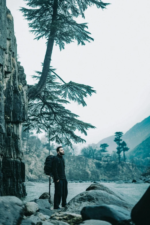 a person with a backpack standing by some rocks