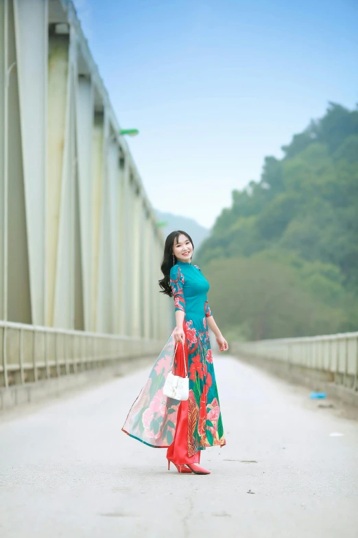 woman standing in the middle of the bridge wearing a red and blue gown