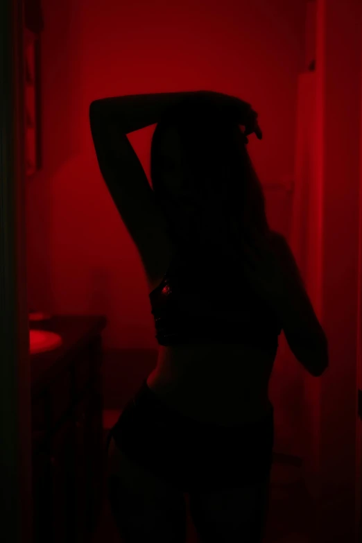 a woman wearing underwear poses in the dark