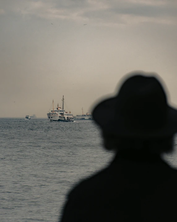 a lone boat sits in the distance behind a person