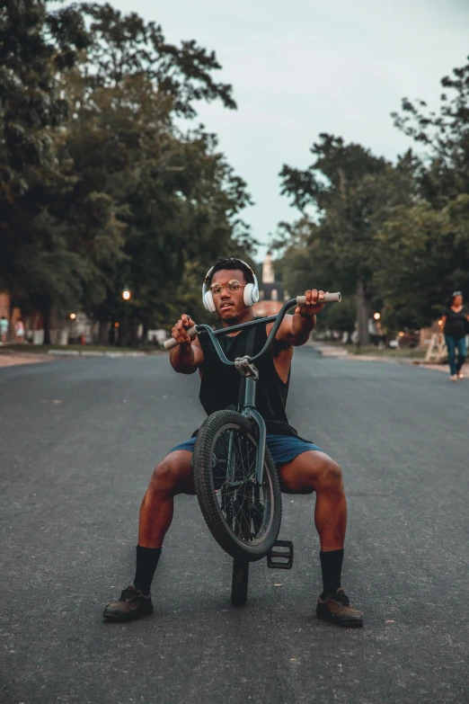 a man with a bicycle sits in the street