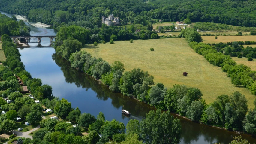 a river with some trees and houses near by