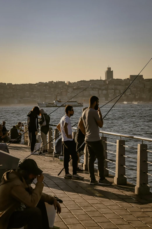 people on dock in front of large body of water