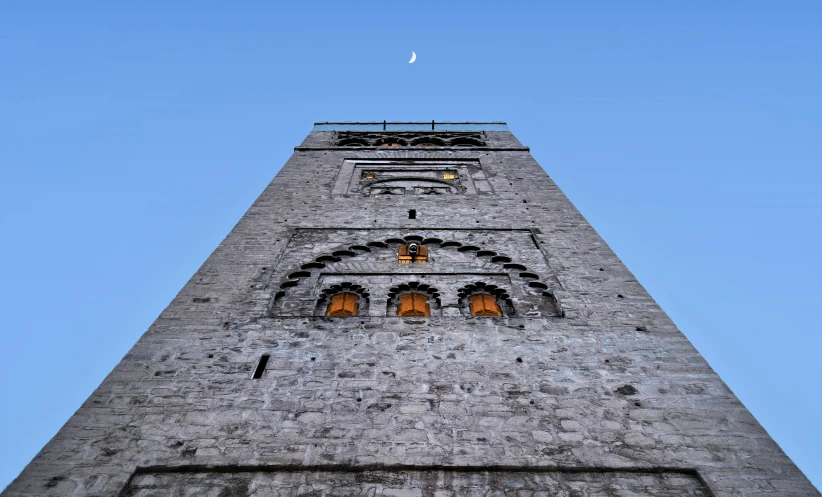 looking up at the tall stone tower with carvings on it