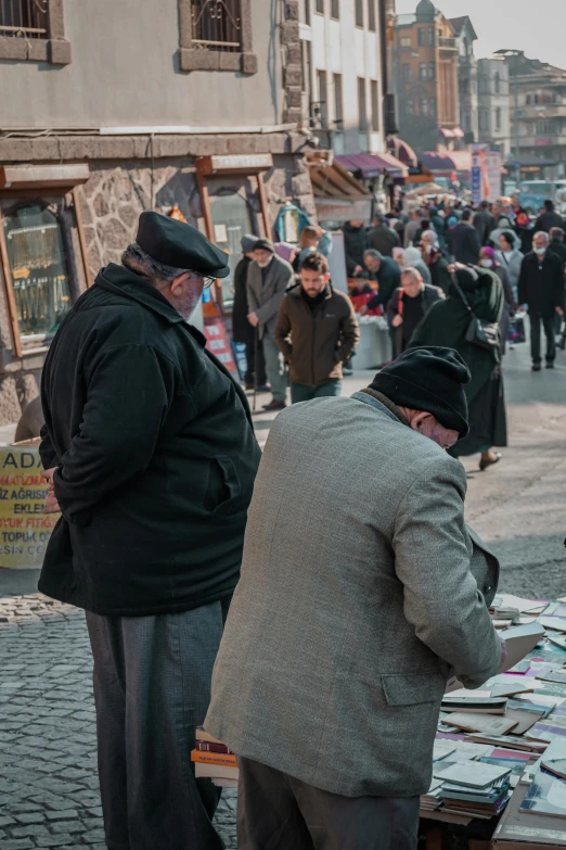 a group of men standing in front of a street vendor