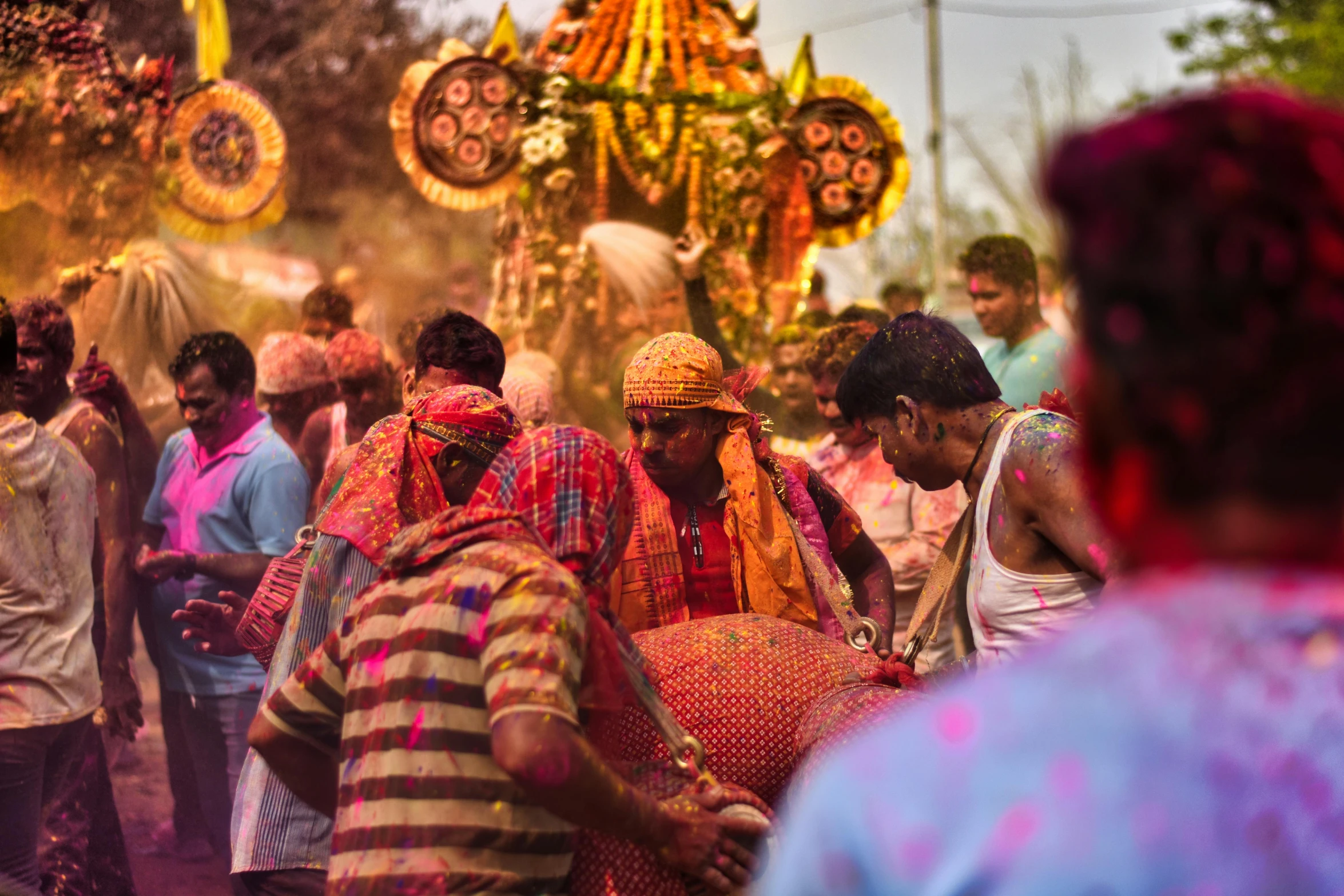 group of people celeting with colored powder and mud