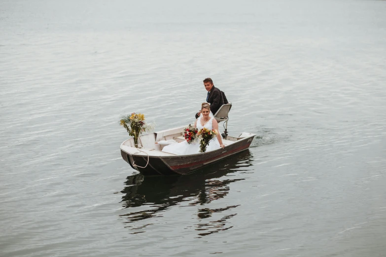 the bride and groom is sitting in a small boat