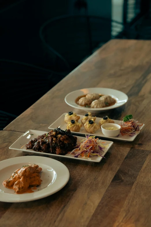 four plates of food sitting on a wooden table