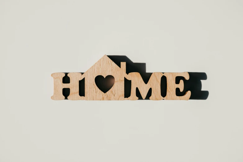 a house is cut out of wood with the words home