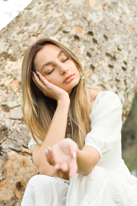 a woman sitting on a rock looking sad