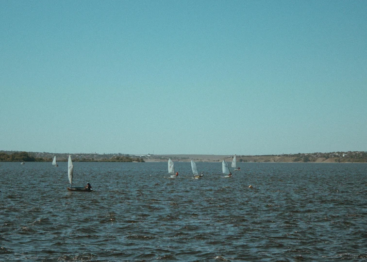 a group of sail boats riding on top of a large body of water