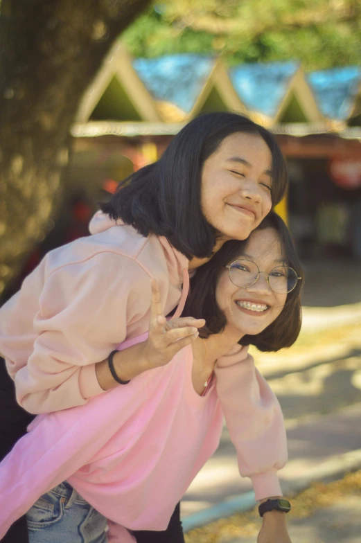 two asian women in pink are smiling and posing for a po