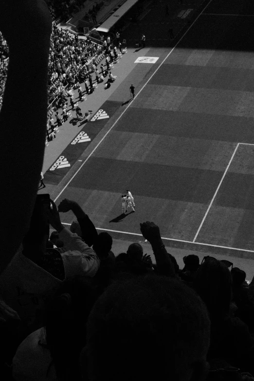 crowd watching game in large arena with man swinging tennis racket