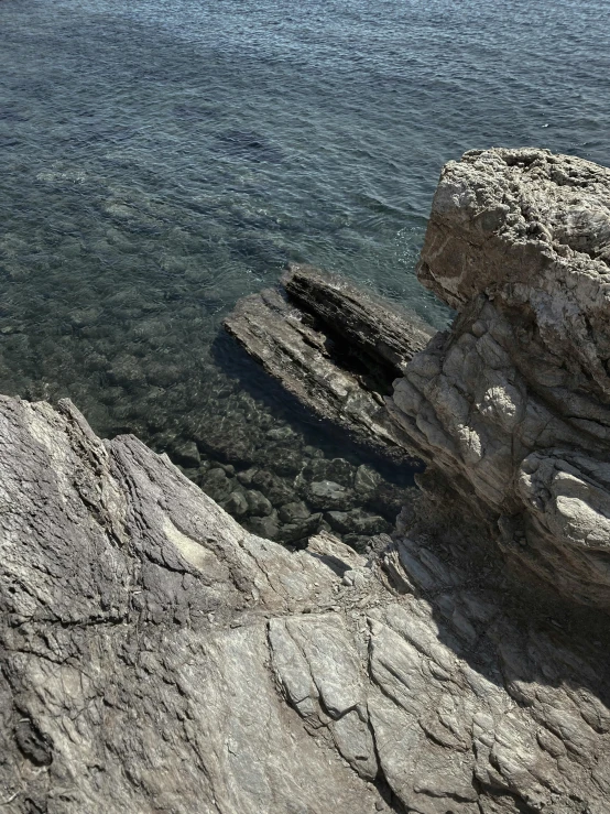 a rocky shoreline with the ocean in the distance