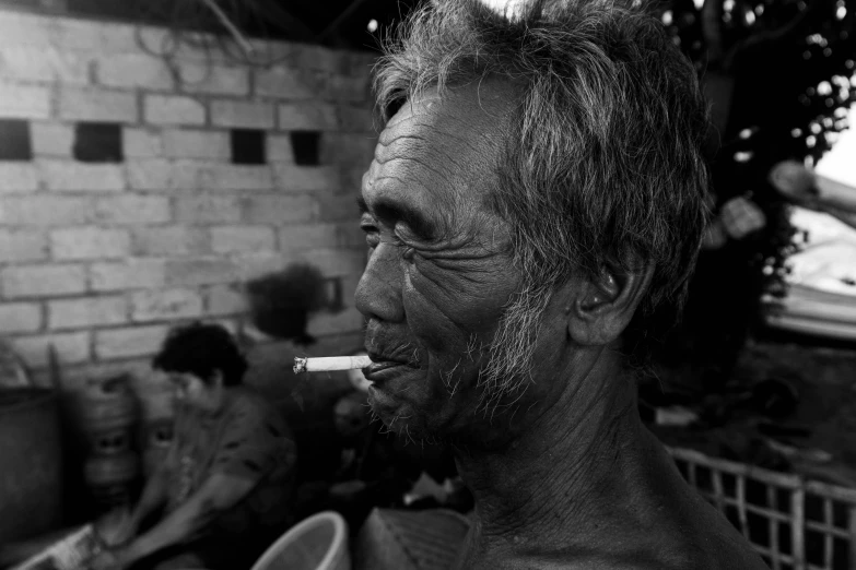 an old man with  on smoking a cigarette