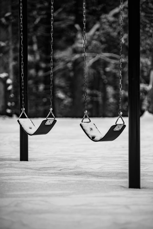 two swings are next to each other in black and white
