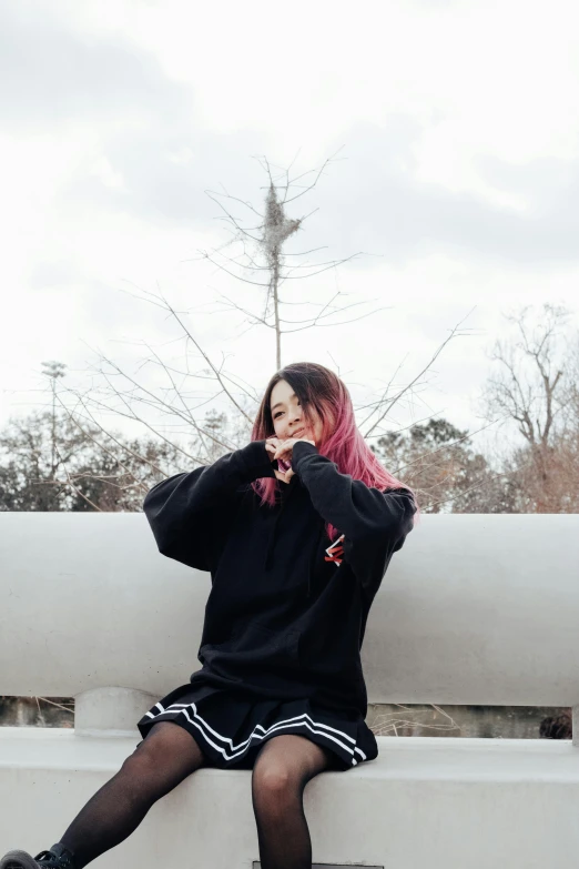 a woman sitting on top of a white bench