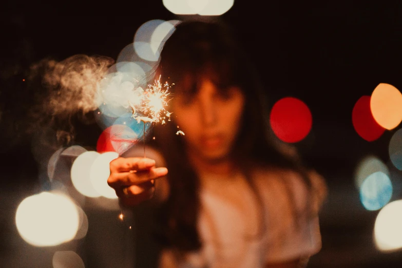 the woman is posing with her fireworks near her