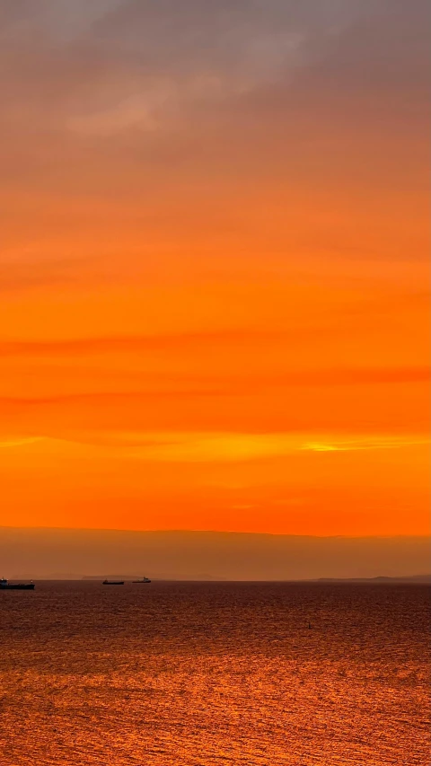 a large boat with people in the distance in the ocean