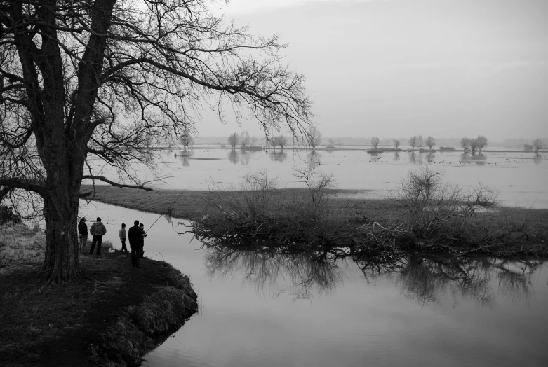 a group of people gather around a pond