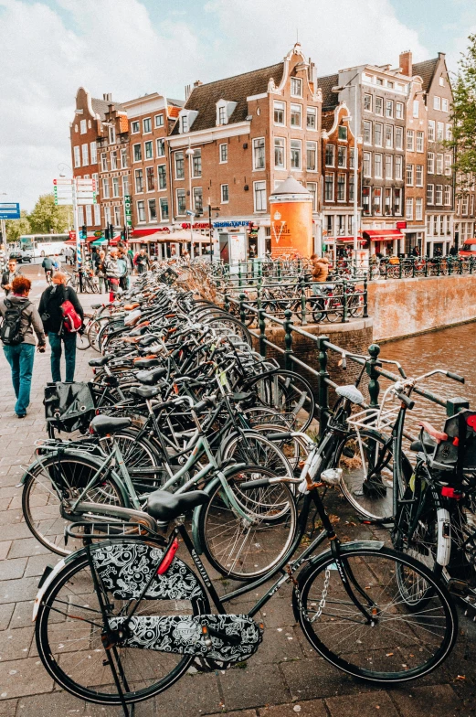 many bikes are shown along the sidewalk next to a canal