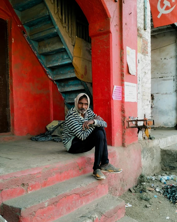 a man sitting on the stairs next to the building