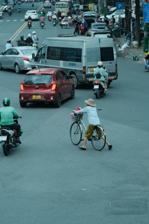 a person riding a bike while another person riding a motorcycle on a road