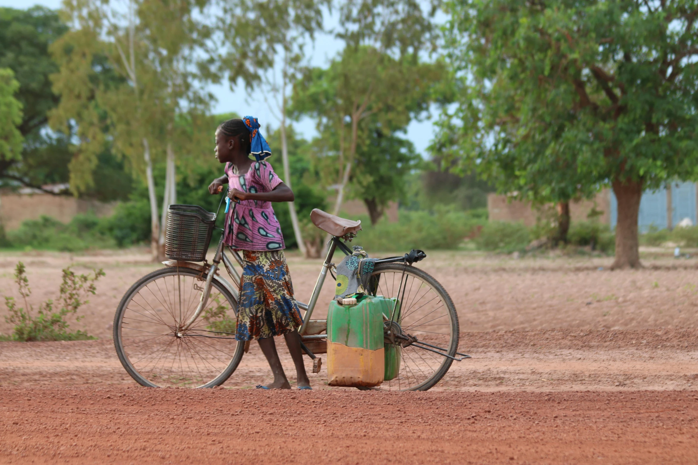 a girl and bicycle with her luggage standing together