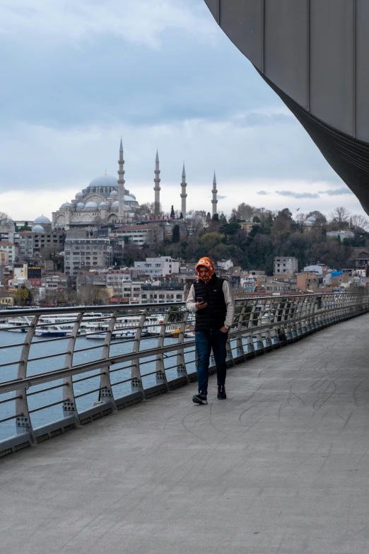 a person standing on top of a bridge next to a body of water