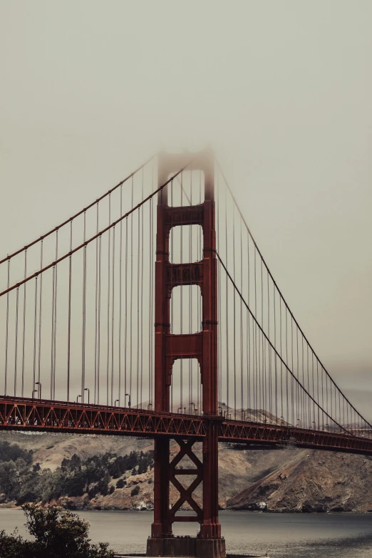 a very tall bridge over some water and mountains