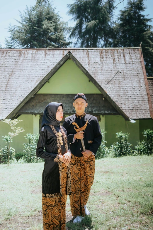 two asian women pose in front of their home