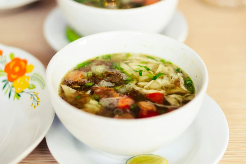 a plate with a bowl and some bowls full of soup