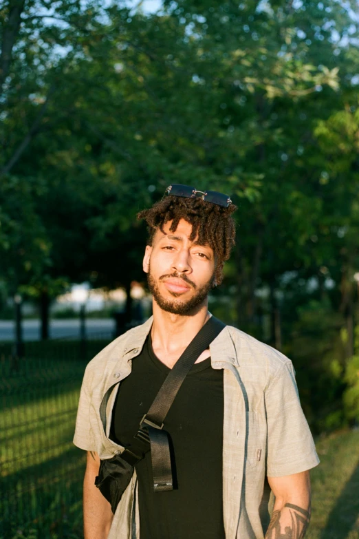 a young man with dreadlocks and  posing for a pograph