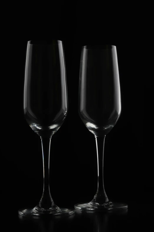 two wine glasses are sitting side by side