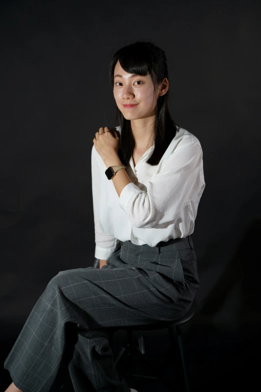 a woman is posing for the camera wearing slacks