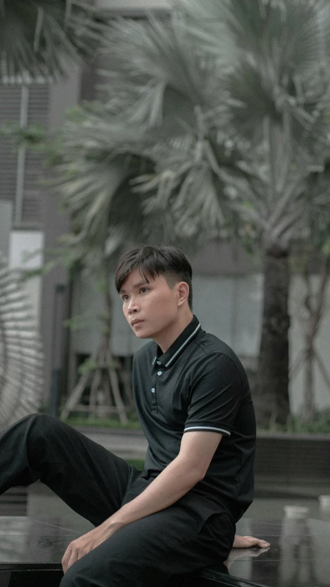 a young man is sitting on top of a bench