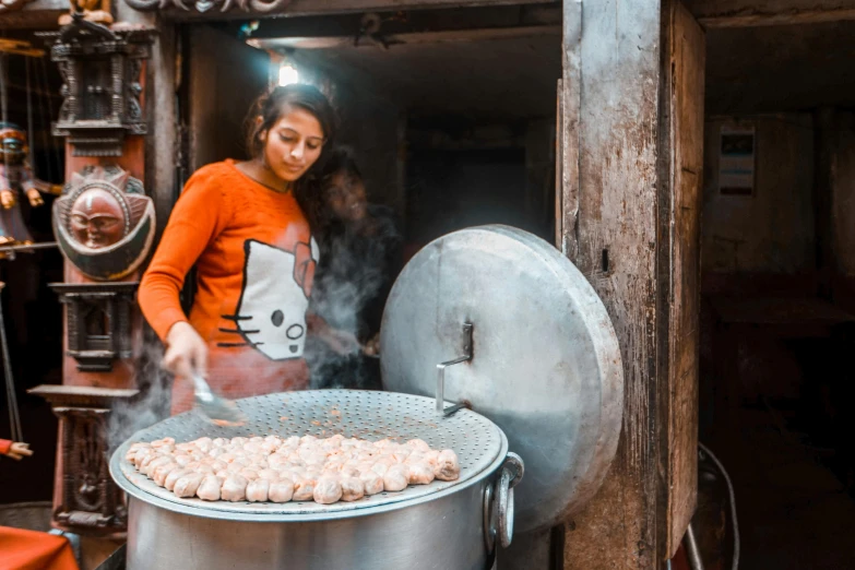 a girl cooks food inside a large pot