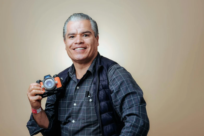 an older man posing with a digital camera