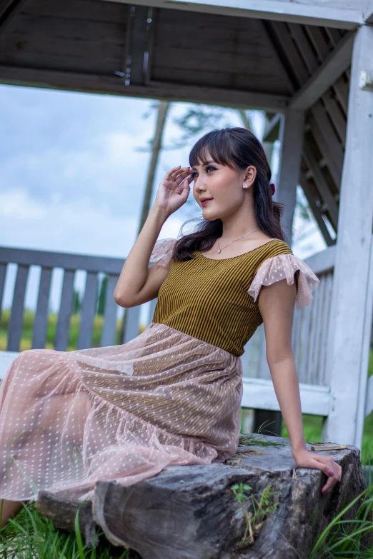 a girl sits on the ground in a tulle skirt and brown top