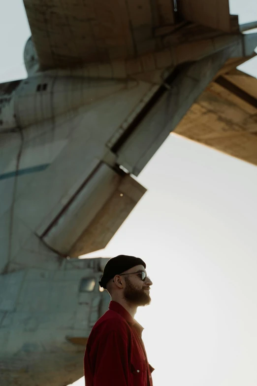 a man standing outside an airplane with his head turned to the side