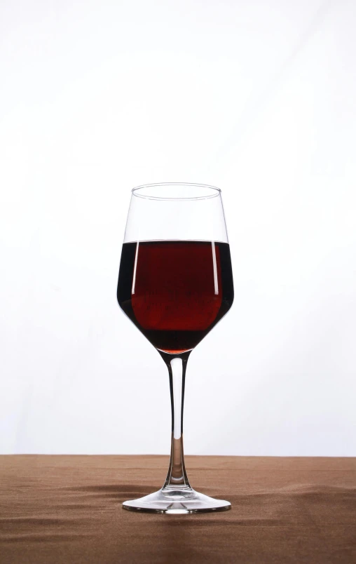 a glass of red wine sits on a table