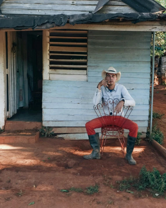 a man in cowboy attire sitting on a chair