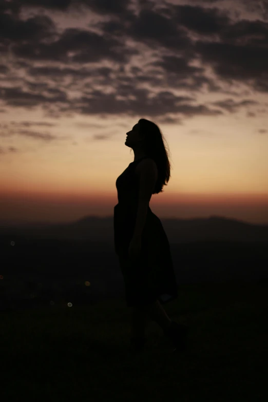 a silhouette of a woman at sunset or dawn