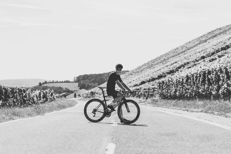 person riding on top of the road next to a cornfield