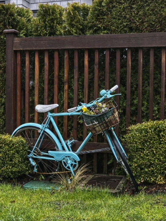 a vintage bicycle locked up to a wooden fence
