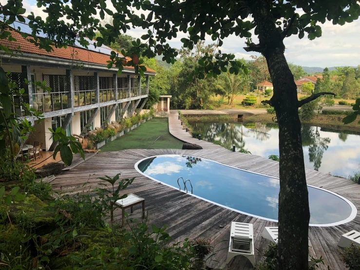 a view from a deck, showing an open patio, and an empty pool in the foreground